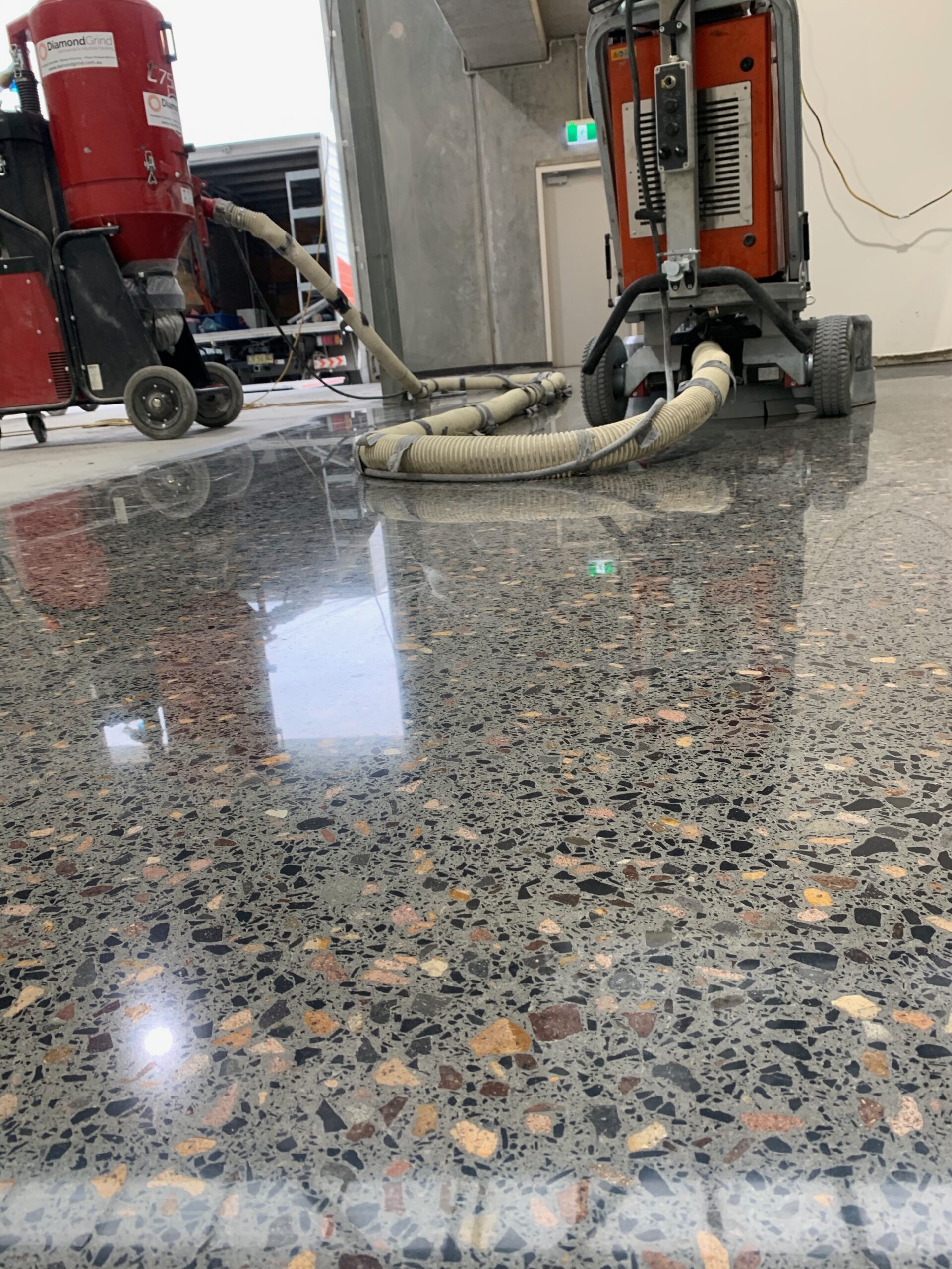 The mechanical process of creating concrete polished floors using heavy-duty diamond grinding machinery for a seamless, mirror-like finish.