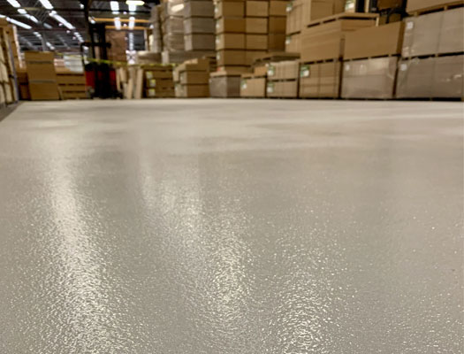 Large-scale industrial epoxy floor in a Newcastle factory showing high-gloss durability and forklift-ready surface.