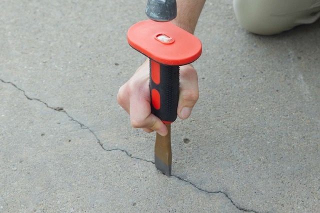 Repairing structural cracks in concrete during the preparation phase to prevent reflective cracking in the final floor finish.