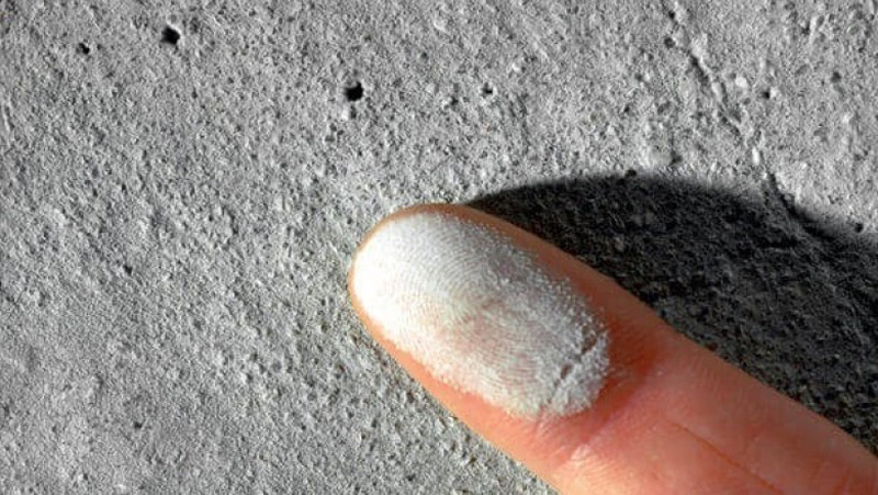 Testing for concrete laitance by checking for chalky dust residue, a sign of a weak surface that will cause floor paint to peel.